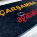 Siyah zeminli turuncu kırmızı logolu paspas P7847